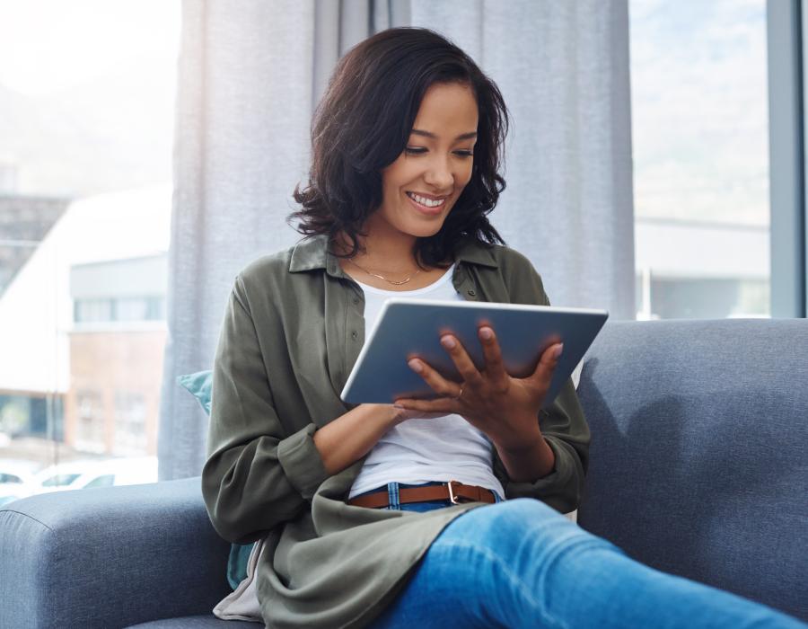 Die E-Mail Bewerbung bequem von zu Hause verfassen Frau auf Sofa bewirbt sich. E-mail Bewerbung